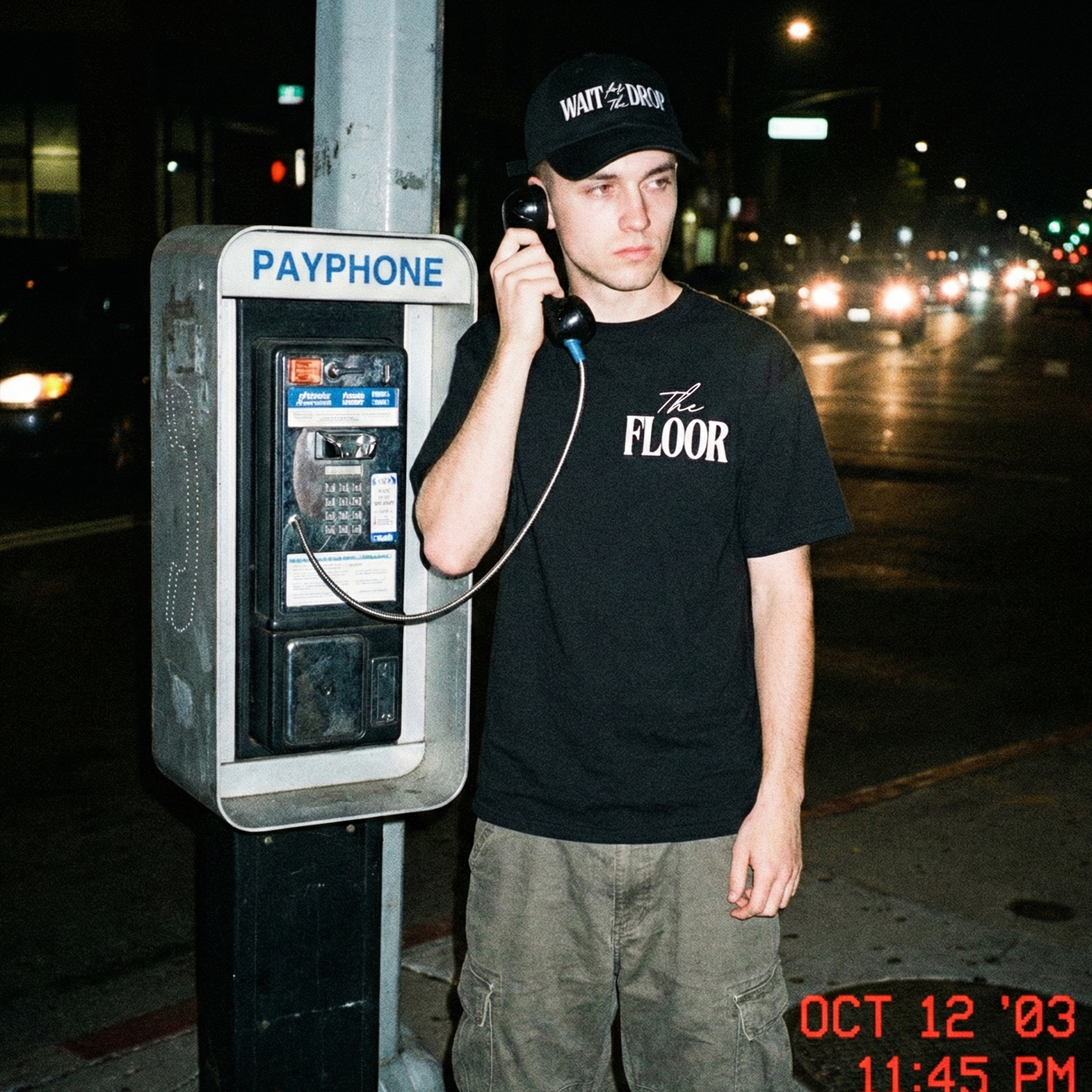 Person using a payphone at night with timestamp on the bottom right corner.